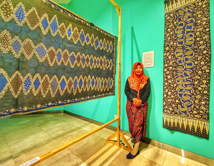 Sticking together: Nurul Maslahah, a 21-year-old batik artisan from Batang, Central Java, stands in front of her batik piece 