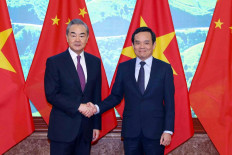 China's Foreign Minister Wang Yi (left) shakes hands with Vietnam's Deputy Prime Minister Tran Luu Quang in Hanoi on Dec. 1, 2023.