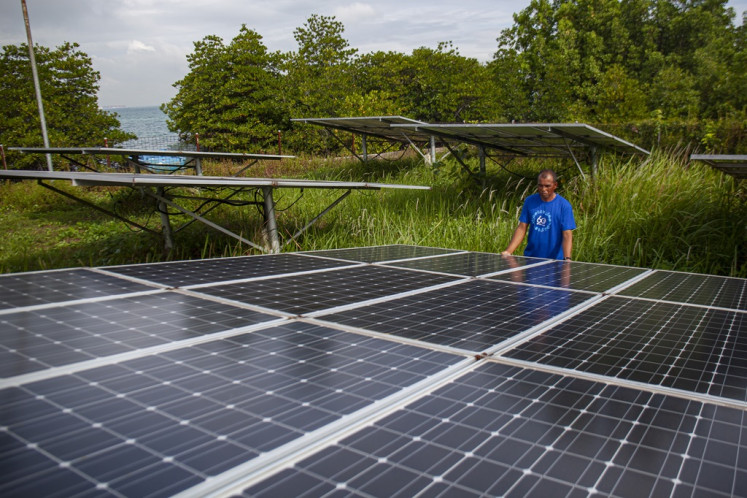 A worker inspects solar photovoltaic panels on Dec. 12, 2023, at the Mecan Island Solar Power Plant in Batam, Riau Islands province.