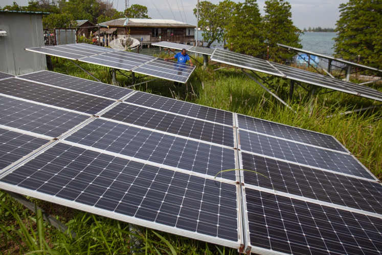 A worker checks on a solar panel at the Mecan Island Solar Power Plant in Riau Islands on Dec. 12, 2023.