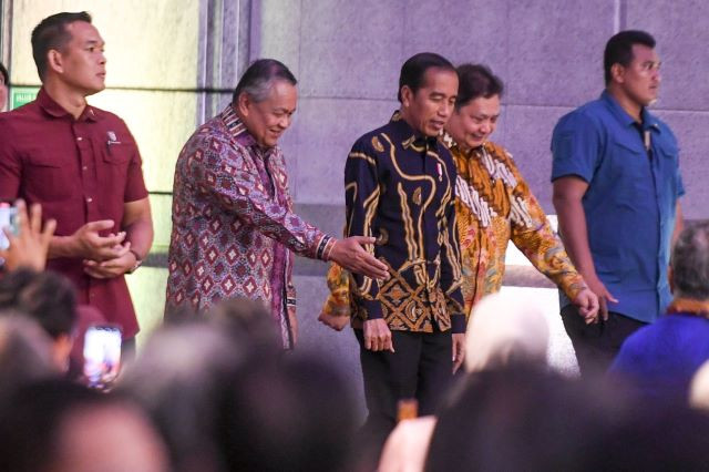 After you: Bank Indonesia (BI) Governor Perry Warjiyo (second left) gestures on Nov. 29, 2023, as he walks alongside President Joko “Jokowi” Widodo (center) and Coordinating Economic Minister Airlangga Hartarto (second right) while attending the BI Annual Meeting.