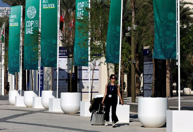 Wrapping up: A delegate pulls luggage on Dec. 12, 2023 as she walks past the venue of the United Nations Climate Change Conference (COP28) in Dubai, the United Arab Emirates.