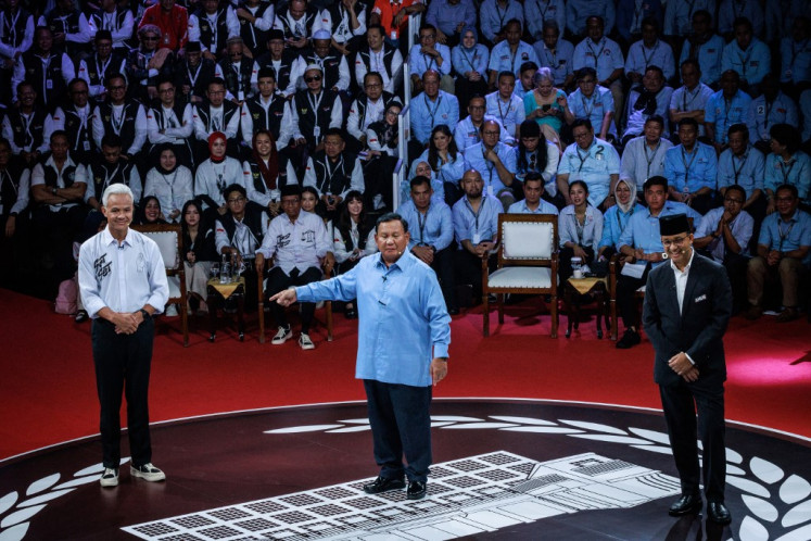 Defense Minister and presidential candidate Prabowo Subianto (center) along with the other two presidential candidates, former Jakarta governor Anies Baswedan (right) and former Central Java governor Ganjar Pranowo, speaks during the first presidential election debate at the General Elections Commission (KPU) office in Jakarta on Dec. 12, 2023.