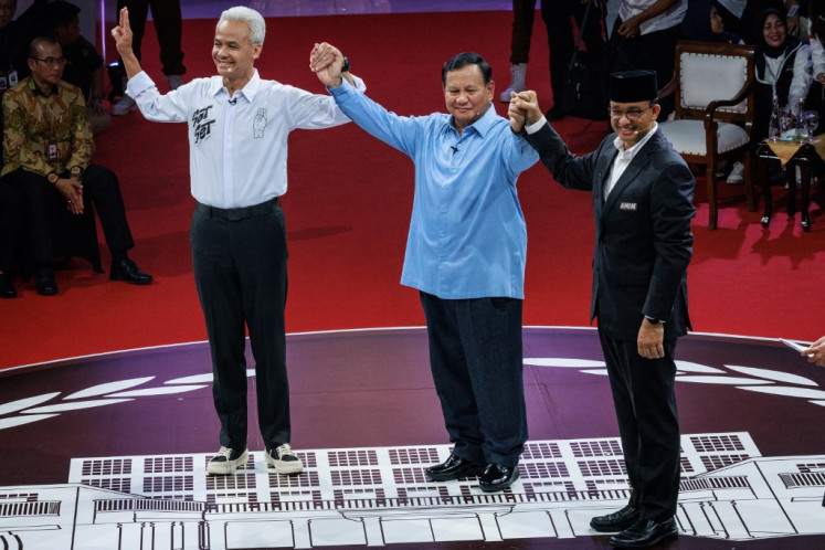 Presidential candidates (from left) Ganjar Pranowo, Prabowo Subianto and Anies Baswedan link hands at the close of the first presidential debate, held on Dec. 12, 2023 at the Jakarta headquarters of the General Elections Commission (KPU).