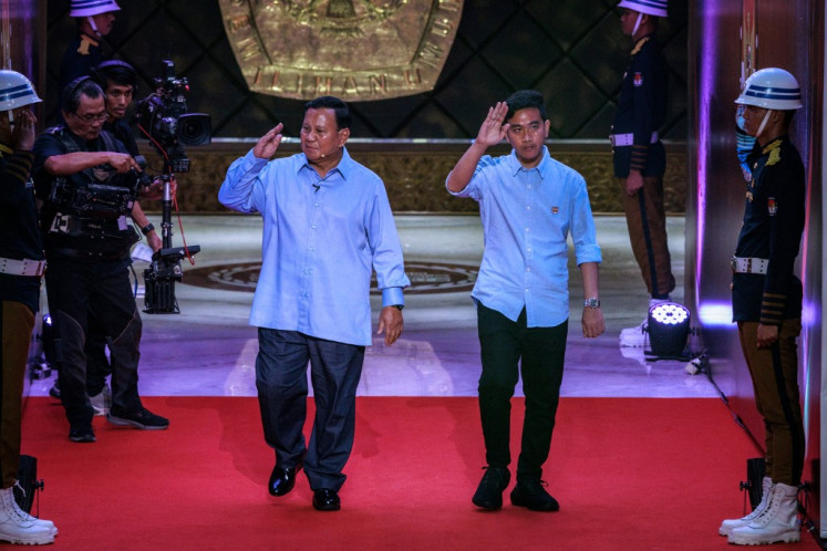Presidential candidate and Defense Minister Prabowo Subianto (left) and vice presidential candidate Gibran Rakabuming Raka arrive to attend the first presidential election debate at the General Elections Commission (KPU) office in Jakarta on Dec. 12, 2023.