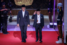 Presidential candidate and former Jakarta governor Anies Baswedan (left) and vice presidential candidate Muhaimin Iskandar arrive to attend the first presidential election debate at the General Elections Commission (KPU) office in Jakarta on Dec. 12, 2023.