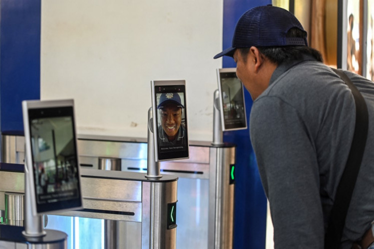 Everyday AI: A man scans his face on June 22, 2023, before boarding a train at Gubeng Station in Surabaya, East Java.