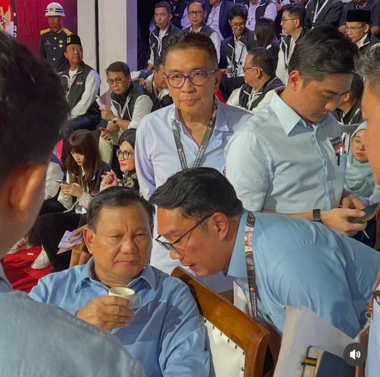 Golkar Party politician Ridwan Kamil (right) speaks with presidential candidate Prabowo Subianto (left) during a break in the first official presidential debate on Dec. 12, 2023.