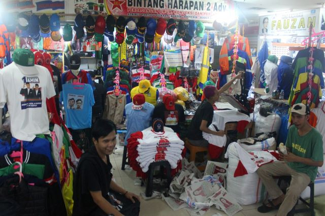 Employees of a T-shirt printing company pack customer orders to be shipped on Dec. 12, 2023, at Senen Market in Central Jakarta. Several traders said their sales increased threefold ahead of the February 2024 election.