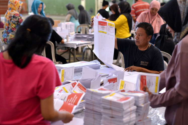 Workers sort and fold ballots for the 2024 legislative election on Dec. 13, 2023, in Denpasar, Bali.