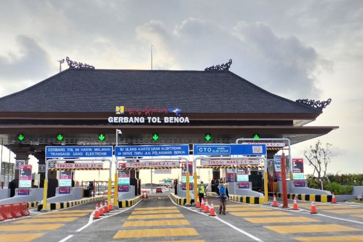 Workers prepare the Benoa toll gate of the Bali Mandara toll road to welcome users ahead of the Group of 20 Summit in November 2022. The Public Works and Housing Ministry started the trial period of a contactless multi-lane free flow system on Dec. 12, 2023.

