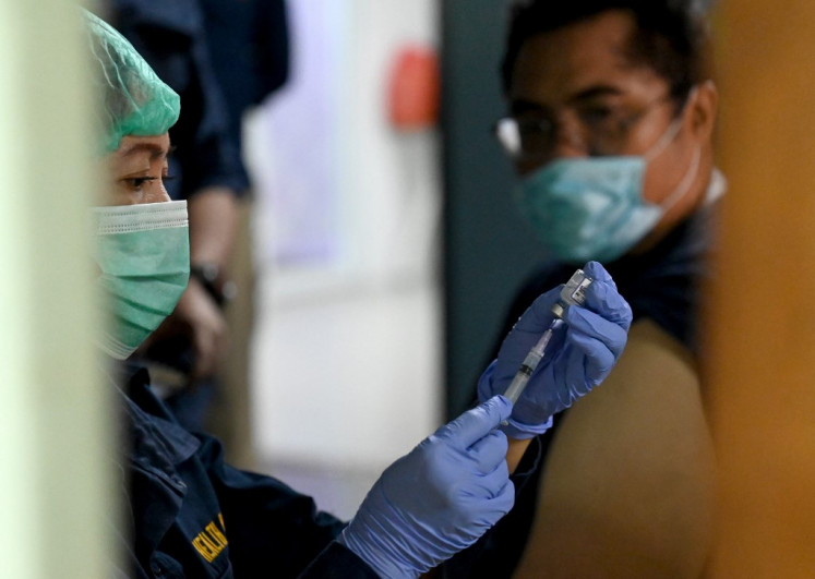 A health worker prepares a dose of the COVID-19 coronavirus booster vaccine for airport workers at Ngurah Rai International Airport near Denpasar, Bali on Jan. 30, 2023. 