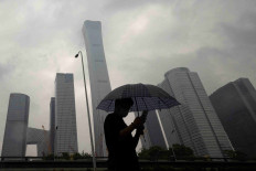 A man walks in the Central Business District on a rainy day, in Beijing, China, July 12, 2023.