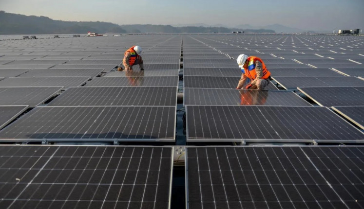 Final tweaks: Technicians check panels on Sept. 29, 2023, at the Cirata floating solar photovoltaic plant, located at the Cirata Reservoir in Purwakarta, West Java. President Joko “Jokowi” Widodo inaugurated the floating solar power plant, the largest in Southeast Asia, on Nov. 9.