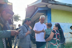 Presidential candidate Ganjar Pranowo (center) interacts with locals during his campaign tour of Bojasari village in Kertek district, Wonosobo regency, Central Java, on Monday. Ganjar stayed overnight at a resident's house and tried tempe kemul, a local dish.