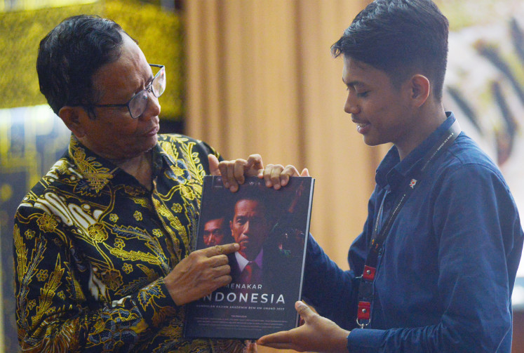 Vice presidential candidate Mahfud MD (left) receives a gift from a student representative of Andalas University (Unand) after a discussion of his camp’s platform hosted by the Andalas Lawyers Club in Padang, West Sumatra, on  Dec. 18, 2023. Mahfud briefed the students on his and presidential candidate Ganjar Pranowo’s eight-pronged quick win strategy for the 2024 presidential election.