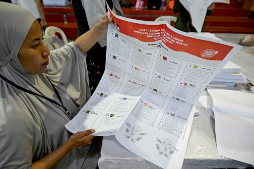 Staff members fold ballot papers ahead of the 2024 general election at the Denpasar Election Commission Logistics Warehouse in Denpasar, Bali on Dec. 14, 2023.