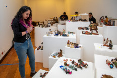 Coordinator of the Del Carmen Alto Museum, Maria Gabriela Mena, observes figures depicting a biblical and everyday scenes from Colonial Quito, during the assembly of the manger at the Del Carmen Alto Museum in Quito, on Dec. 14, 2023. A hunchback suffering from goiter, a decapitated child in the hands of a soldier, a woman with a bloody face and other unusual images make up a peculiar manger in Quito, preserved for three centuries in a cloister monastery.