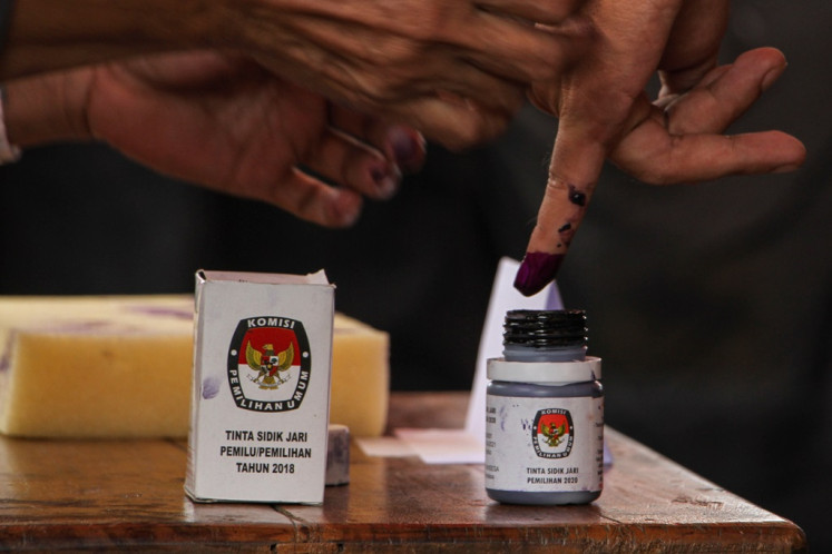 A voter dips their finger in ink after casting their vote during a voting simulation for 2024 general election in Makassar, South Sulawesi on Dec. 23, 2023. Makassar Elections Commission (KPU Makassar) holds the simulation as a technical tutorial for poll administrators ahead of the 2024 general election voting day, slated for Feb. 14, 2024.