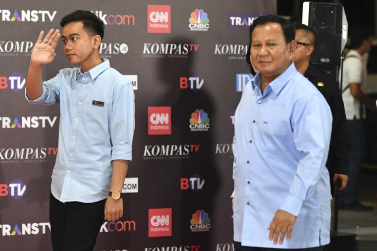 Presidential candidate Prabowo Subianto (right) and running mate Gibran Rakabuming Raka walk into the Jakarta Convention Center ahead of the second 2024 election debate on Dec. 22, 2023.