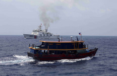 A Philippine supply boat sails near a Chinese Coast Guard ship during a resupply mission for Filipino troops stationed at a grounded warship in the South China Sea, in this file photo taken on Oct. 4, 2023.