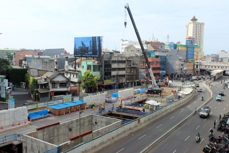 Motorists pass the construction site for the second phase of the MRT Jakarta project on Nov. 28, 2023. The project's second phase will see the railway service extended from Bundaran HI in Central Jakarta to Kota Tua in West Jakarta.