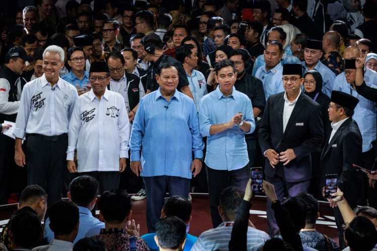 Three presidential candidates, Anies Baswedan (second right), Ganjar Pranowo (left) and Prabowo Subianto (center) along with respective vice presidential candidates pose for photos on Dec. 12, 2023, after the first presidential election debate at the General Elections Commission (KPU) office in Jakarta.