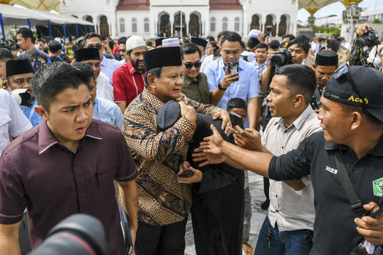 Presidential candidate Prabowo Subianto (center) hugs a supporter during a visit to Baiturrahman mosque in Banda Aceh, Aceh, on Dec. 26, 2023.