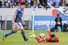 Thailand's Jaroensak Wonggorn (right) falls on the pitch after a challenge from Japan's Mao Hosoya (left) during the New Years Day international football friendly match between Japan and Thailand at the National Stadium in Tokyo on January 1, 2024. 