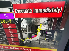 This image taken in Hong Kong on January 1, 2024 shows a warning message on a screen from a live feed on NHK World asking people to evacuate from the area after a series of major earthquakes hit central Japan. 