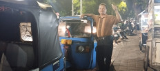 Sutoyo, a 58-year-old ‘bajaj’ driver from Nganjuk, East Java, gestures on Dec. 20, 2023 beside his three-wheeled vehicle in Gandaria Utara, South Jakarta. The blue ‘bajaj’ is more environmentally friendly, as they run on compressed natural gas (CNG).