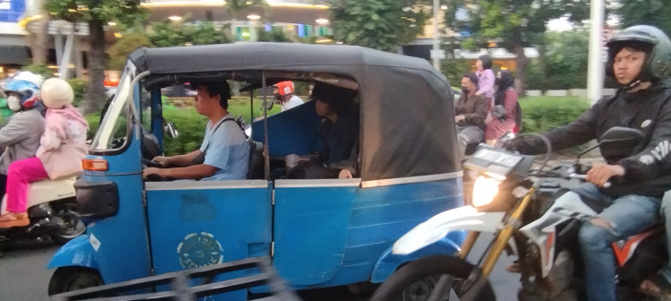 A motorized tricycle taxi running on compressed natural gas (CNG) conveys a passenger on Jl. Kyai Haji Moh. Syafi'i Hadzami in South Jakarta on Dec. 20, 2023.