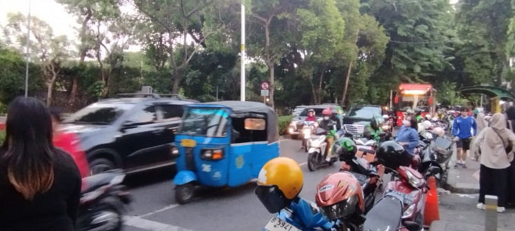 A blue bajaj, running on compressed natural gas (CNG), passes on Dec. 20, 2023, through Jl. Kyai Haji Moh. Syafi'i Hadzami in South Jakarta.