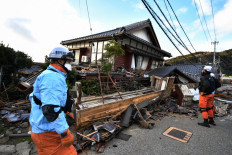 Firefighters inspect collapsed wooden houses in Wajima, Ishikawa prefecture on January 2, 2024, a day after a major 7.5 magnitude earthquake struck the Noto region in Ishikawa prefecture in the afternoon. Japanese rescuers battled against the clock and powerful aftershocks on January 2 to find survivors of a major earthquake that struck on New Year's Day, leaving a trail of destruction. 