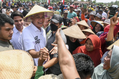 Presidential candidate Ganjar Pranowo (third left, in cap) greets farmers on Dec. 2, 2023 while on the campaign trail in Demak, Central Java.