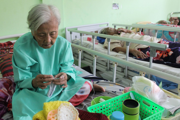 An elderly woman crochets in her room at Griya Wreda nursing home in Surabaya, East Java, on Jan. 5, 2024.