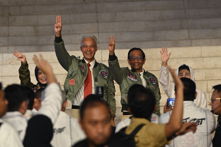 Presidential candidate Ganjar Pranowo and running mate Mahfud MD pose with a three-finger salute upon their arrival at the Istora Senayan stadium in Jakarta on Jan. 7, 2024, ahead of the third televised debate on defense and foreign policy.