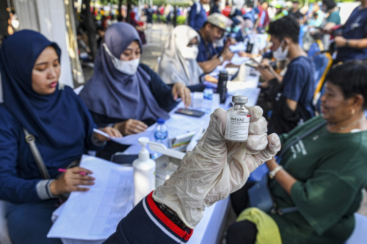 A health workers shows a vial of locally made Inavac COVID-19 vaccine in Jakarta on Dec. 17, 2023.