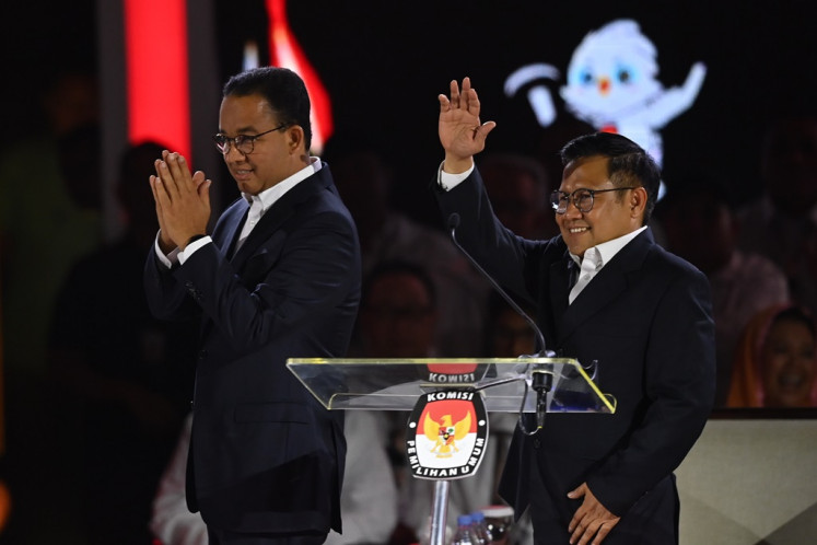Presidential candidate pair Anies Baswedan (left) and Muhaimin Iskandar walk on stage during the third 2024 presidential election debate at Istora Senayan in Jakarta on Jan. 7, 2024. The third debate covered issues of international relations, defense and security.