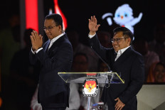 Presidential candidate pair Anies Baswedan (left) and Muhaimin Iskandar walk on stage during the third 2024 presidential election debate at Istora Senayan in Jakarta on Jan. 7, 2024. The third debate covered issues of international relations, defense and security.