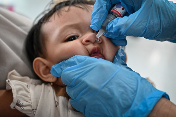 A child receives a vaccine to prevent polio on Aug. 10, 2023, as part of a monthly medical checkup program for children at an integrated services post in Banda Aceh.