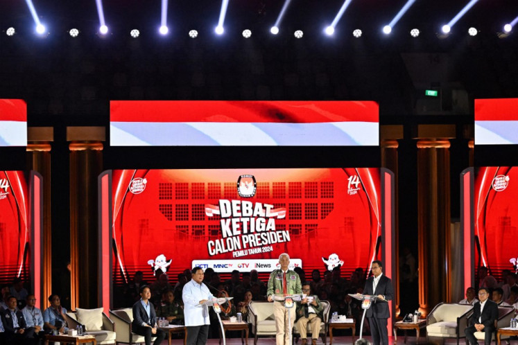 Presidential candidates (from left, standing) Prabowo Subianto, Ganjar Pranowo and Anies Baswedan speak onstage on Jan. 7, 2024 during the third 2024 election debate at the Gelora Bung Karno Sports Complex in Senayan, Jakarta.
