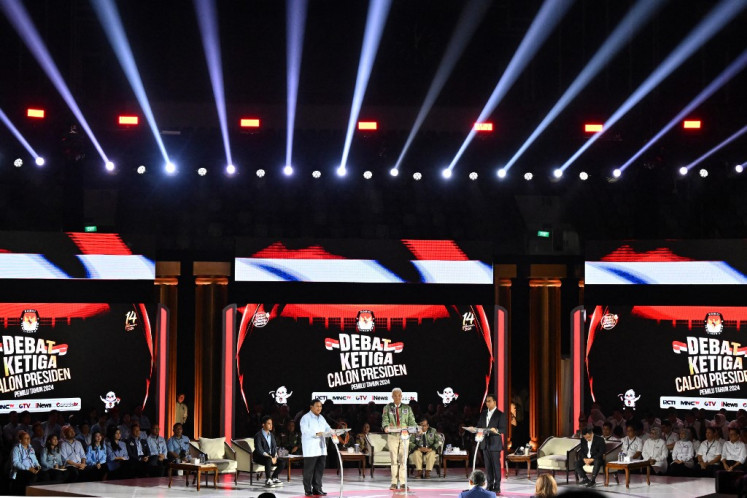 Presidential candidates Prabowo Subianto (left), Ganjar Pranowo (center) and Anies Baswedan stand on the stage during the third presidential debate for the 2024 election at Istora Senayan in Jakarta on Jan. 7, 2024.