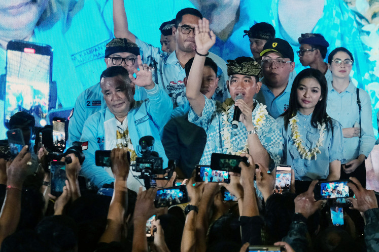 Vice presidential candidate Gibran Rakabuming Raka (center) is accompanied by his wife Selvi Ananda (right) during his campaign in Denpasar, Bali, on Jan. 9, 2024. He urged his supporters and volunteers to work hard so he and presidential candidate Prabowo Subianto could win the election in one round. 