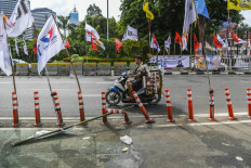 A motorist passes by election campaign banners installed by political parties ahead of the 2024 election in Menteng, Jakarta, on Jan. 8, 2024. The General Elections Commission (KPU) prohibits election candidates and political parties from installing banners and other campaign materials on public facilities.