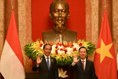 President Joko 'Jokowi' Widodo (left) and Vietnam's President Vo Van Thuong (right) wave during their meeting at the Presidential Palace in Hanoi on January 12, 2024. 