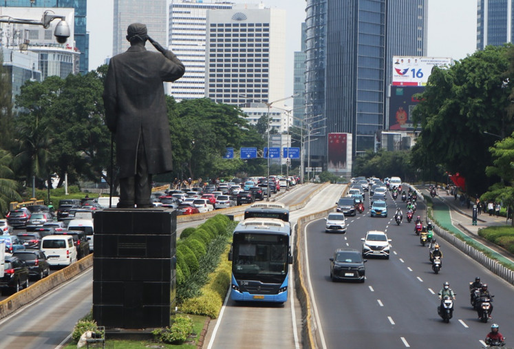Two buses operated by Jakarta-owned bus operator Transjakarta pass through Jl. Sudirman on Dec. 22, 2023, in Jakarta.