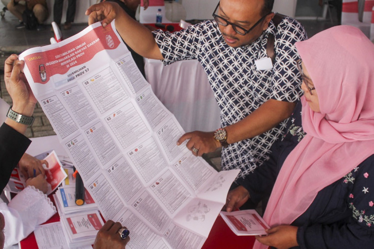 Local poll administrators (KPPS) show a ballot paper for the legislative election to a voter on Dec. 29, 2023, during an election simulation at the South Jakarta Elections Commission (KPU) office in Jakarta. The KPU held voting day simulations to educate the public ahead of polling day slated for Feb. 14.