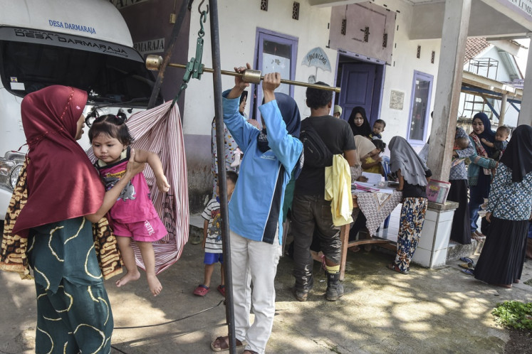 Healthcare workers weigh a children on a scale at an integrated health post (Posyandu) in Ciamis regency, West Java, on Jan. 16, 2024. The government allocated Rp 187.5 trillion in the 2024 state budget for stunting prevention.