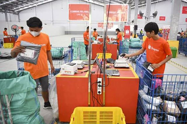 Workers sort packages for shipping on Aug. 30, 2023, at the warehouse of e-commerce giant Shopee in Cengkareng, West Jakarta.
